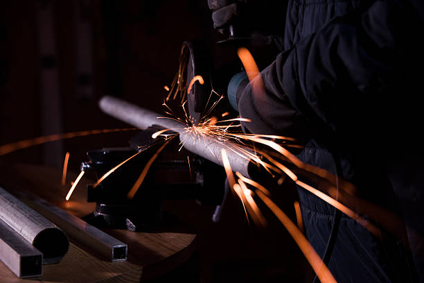 istock worker cutting metal pipe with angle grinder and generating sparks 627047330