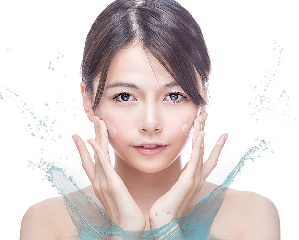 istock Asian beauty applying cream to face with water splash 627049128