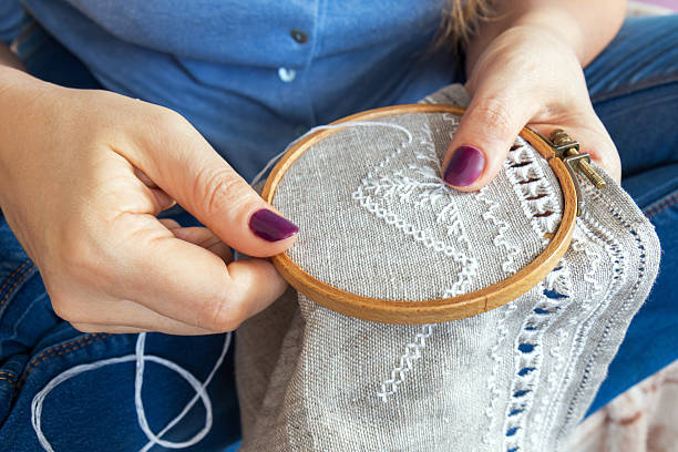ホームスパンリネンにオープンワークの刺繍を行う女性の手。 - thread tailor art sewing ストックフォトと画像