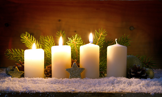 Christmas background with three white advent candles and golden decoration.