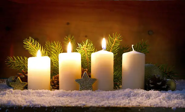 Christmas background with three white advent candles and golden decoration.
