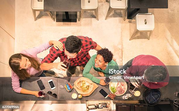 Foto de Vista De Amigos Multirraciais Degustando Vinho E Se Divertindo e mais fotos de stock de Balcão de bar