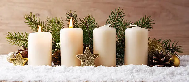 Christmas background with two white advent candles and golden decoration.