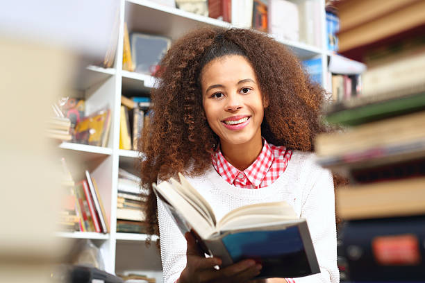 istock Girl reading a book in a bookstore. 627080482