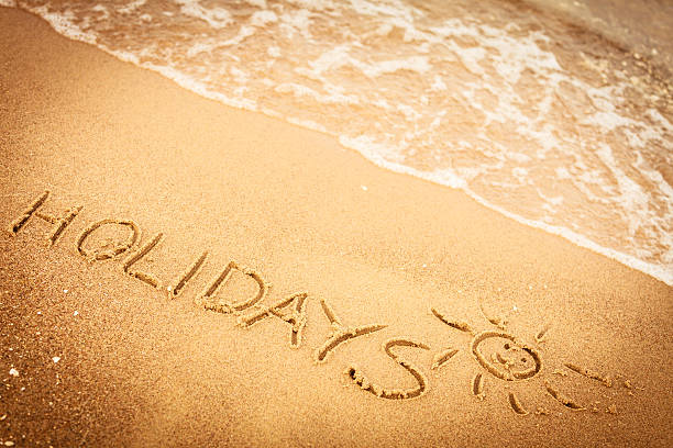 istock The word holidays written in the sand on a beach 627080828
