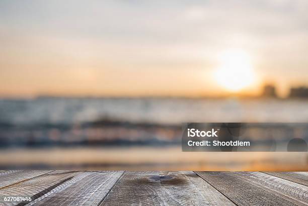 Wooden Free Space On Table And Sunset Over The Sea Stock Photo - Download Image Now - Beach, Table, Backgrounds