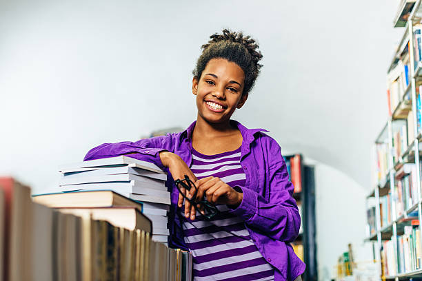 istock Pensive black girl in library posing with books 627081696