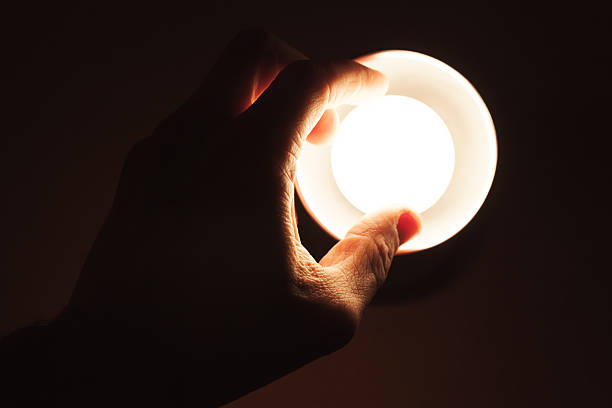 istock Male hand turning on small lamp 627088770