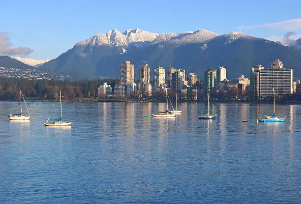 Sailboats on English Bay with Vancouver's Northshore Mountain range in the background on a winter's day. 