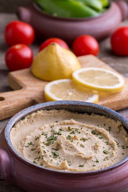 istock Humus in homemade bowl with vegetable around. 627091492