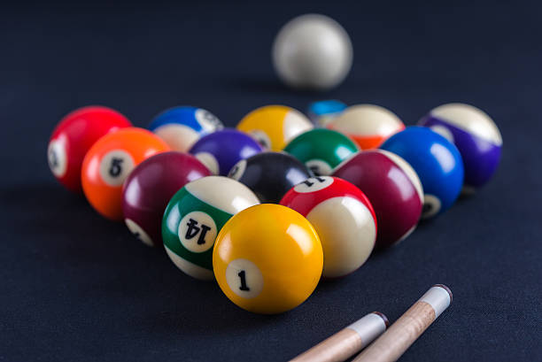 Blue billiard table with balls and cues.