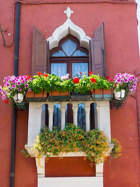 Single Italian window in Burano on red painted walls