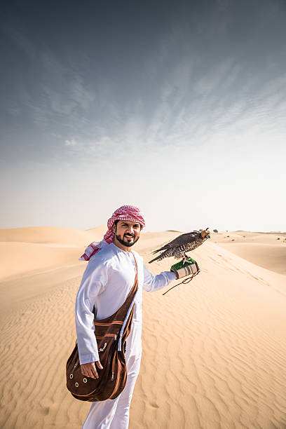 arabic sheik on the desert holding a falcon