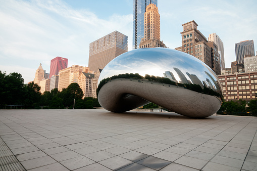 Chicago, USA - June 27, 2013: The Bean and Chicago skyline early in the day in Millennium Park just after sunrise.