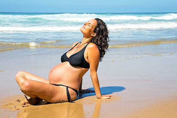 Happy pregnant woman on the beach at the atlantic ocean stock photo