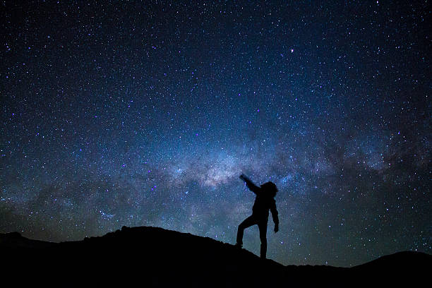 istock Man's silhouette with milky way as background 627101998