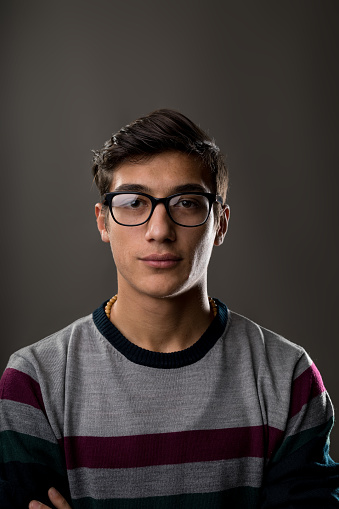 portrait of a young man with glasses on a strped jumper