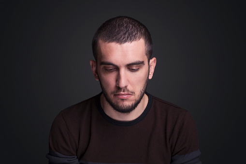 Portrait of young adult with blank expression over gray background ,studio shot
