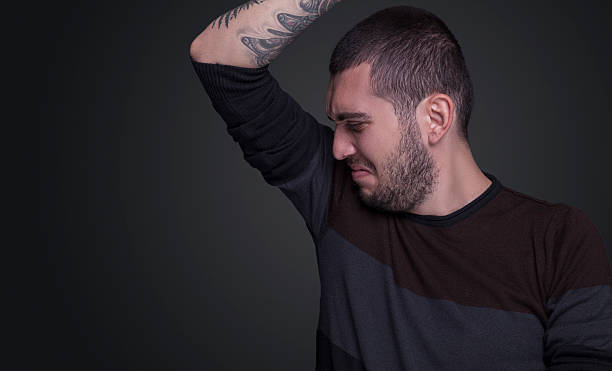 istock Young man sniffing his underarm because of his armpit smell 627111192