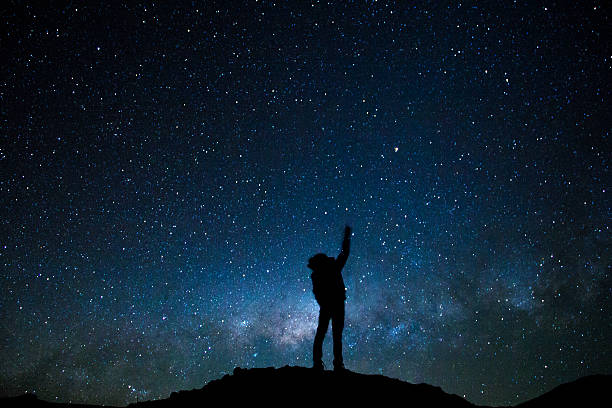 istock Man's silhouette pointing the milky way 627111348