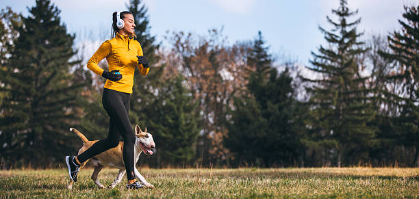 istock Woman running in forest with her dog 627111364