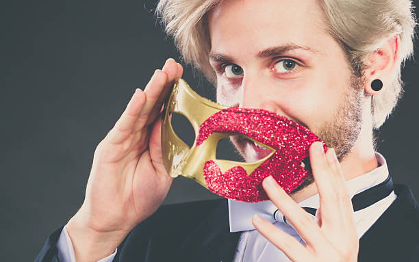 istock Young man in carnival mask on dark 627116608