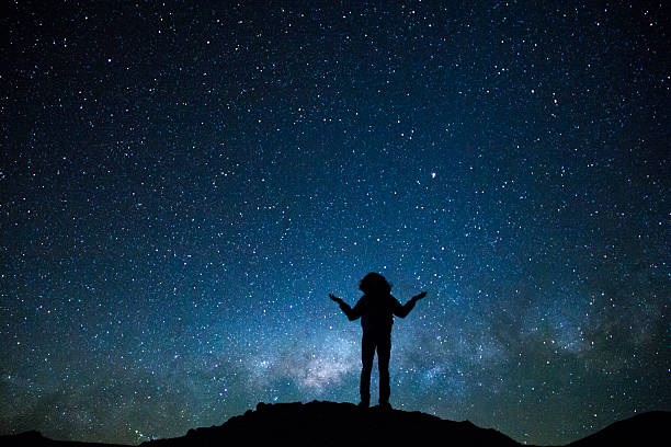 istock Man's silhouette rising both arms with the milky way behind 627125268