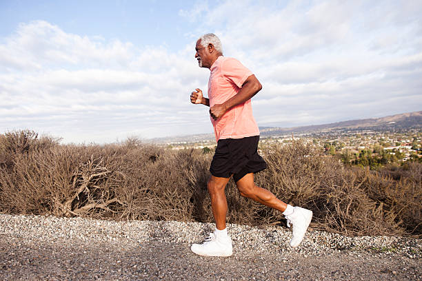 attractive senior man jogging - running jogging mountain footpath imagens e fotografias de stock