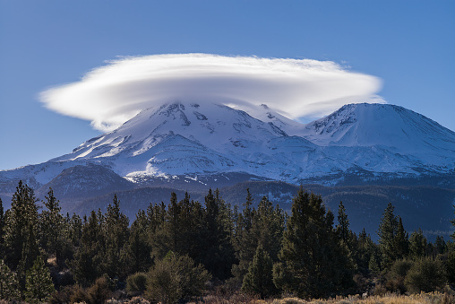 Mount Shasta in northern California with a cloud capping its peak.