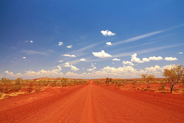 Dirt road across the Pilbara in Australian outback Picturesque unpaved highway across Australian bush. the pilbara stock pictures, royalty-free photos & images