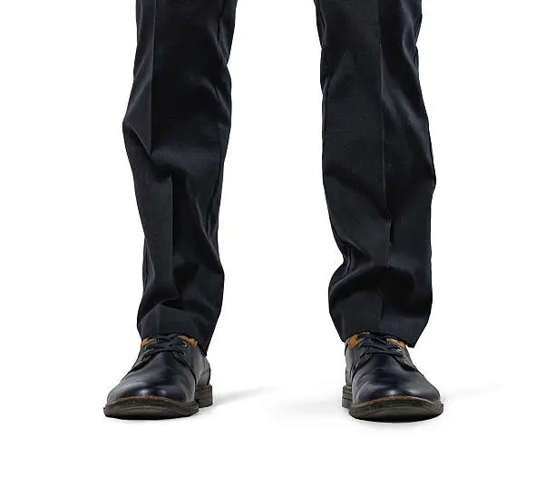 Front view of cropped legs of a businessman isolated on white background. Business staff. Office clothes. Big feet. Domination and superiprity.