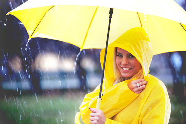 かわいい女の子のための雨です。 - umbrella women storm yellow ストックフォトと画像