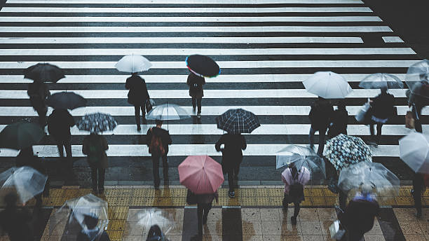 istock People across the crosswalk on a rainy day 627147078