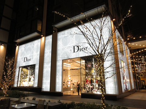 Washington DC, USA-December 2, 2016:  This high end Dior fashion clothing store was spotted at City Center in downtown Washington DC at night during Christmas.  The man at the door is closing the store.  City Center is a retail, office and residential complex in the center of town.  