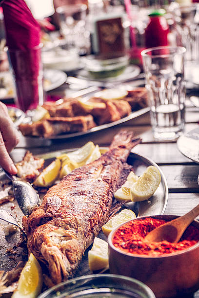 istock Eating Grilled Fish and Fresh Salad in a Restaurant 627163232