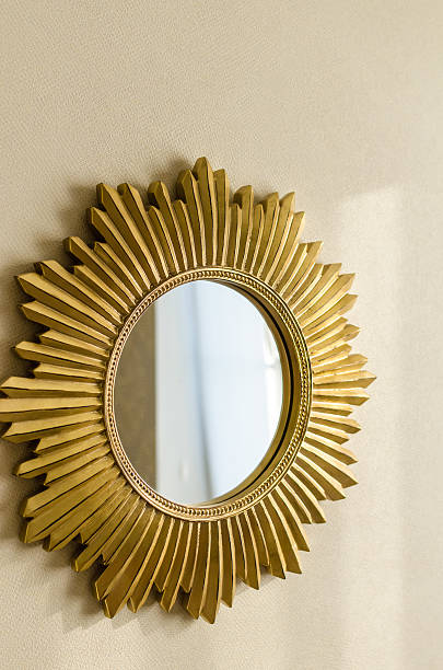 istock Golden modern mirror in shape of sun on the wall 627164342