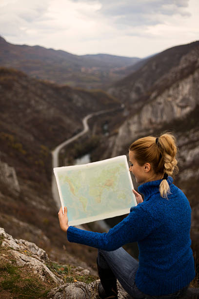 istock Famale tourists on mountain looking into world map, 627169478