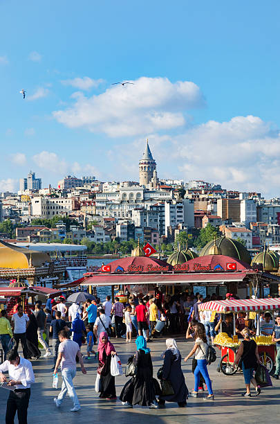 Istanbul, Turkey - July 26, 2016: Fish sandwich (Balik ekmek) at the Eminonu pier near the Galata Bridge.  Background The Golden Horn is seen and the Galata Tower. \