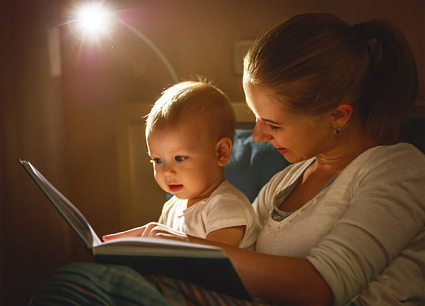 istock mother and baby son reading a book in bed 627170120