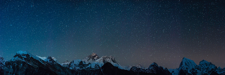 Stars shining above the iconic summit pyramid of Mt. Everest (8848m) and the snow capped mountain peaks of the Khumbu Himalaya deep in the Sargamatha National Park of Nepal, a UNESCO World Heritage Site.