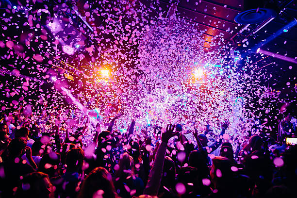 Concert Crowd Concert crowd - picture with a lof of people dancing i a concert, night club with raised their hands up! Amazing colours! party stock pictures, royalty-free photos & images