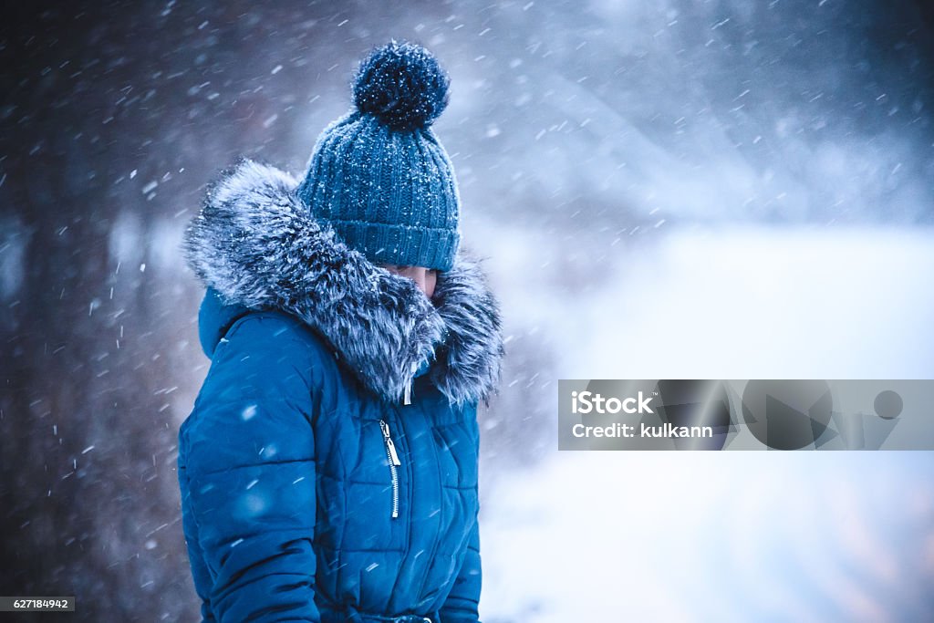 girl has muffled in a warm collar from a blizzard Blizzard Stock Photo