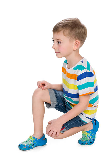istock Cute little boy sits on the white 627196798