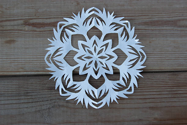 istock paper snowflake on the wooden table 627197240