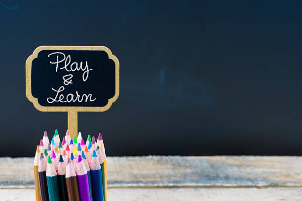 istock Wooden mini blackboard label with message Play and Learn 627198456