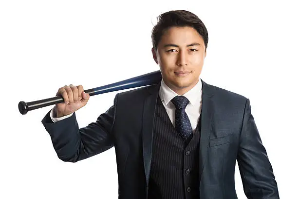 Handsome staring businessman in a suit with vest and tie, holding a baseball bat, staring at camera. White background.