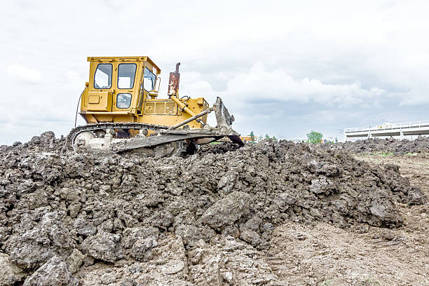 máquina de construção de terraplano pesado está movendo terra em buildin - hydraulic platform earth mover machine machine part - fotografias e filmes do acervo