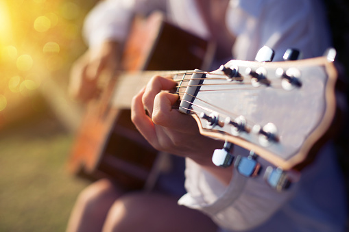 Female hand playing guitar outdoor