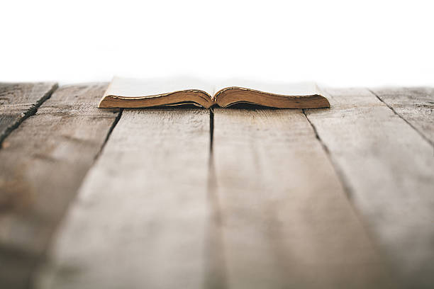 istock Old bible on a wooden table 627203440