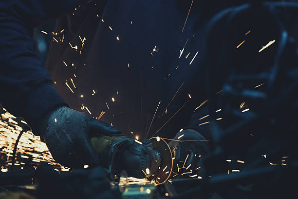istock Worker sawing metal with disk grinder and generating sparks 627203610